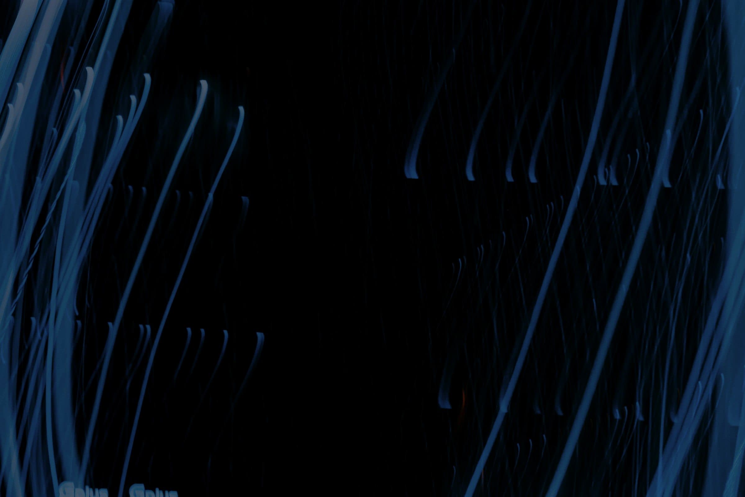 Streaks of blue light across a dark background