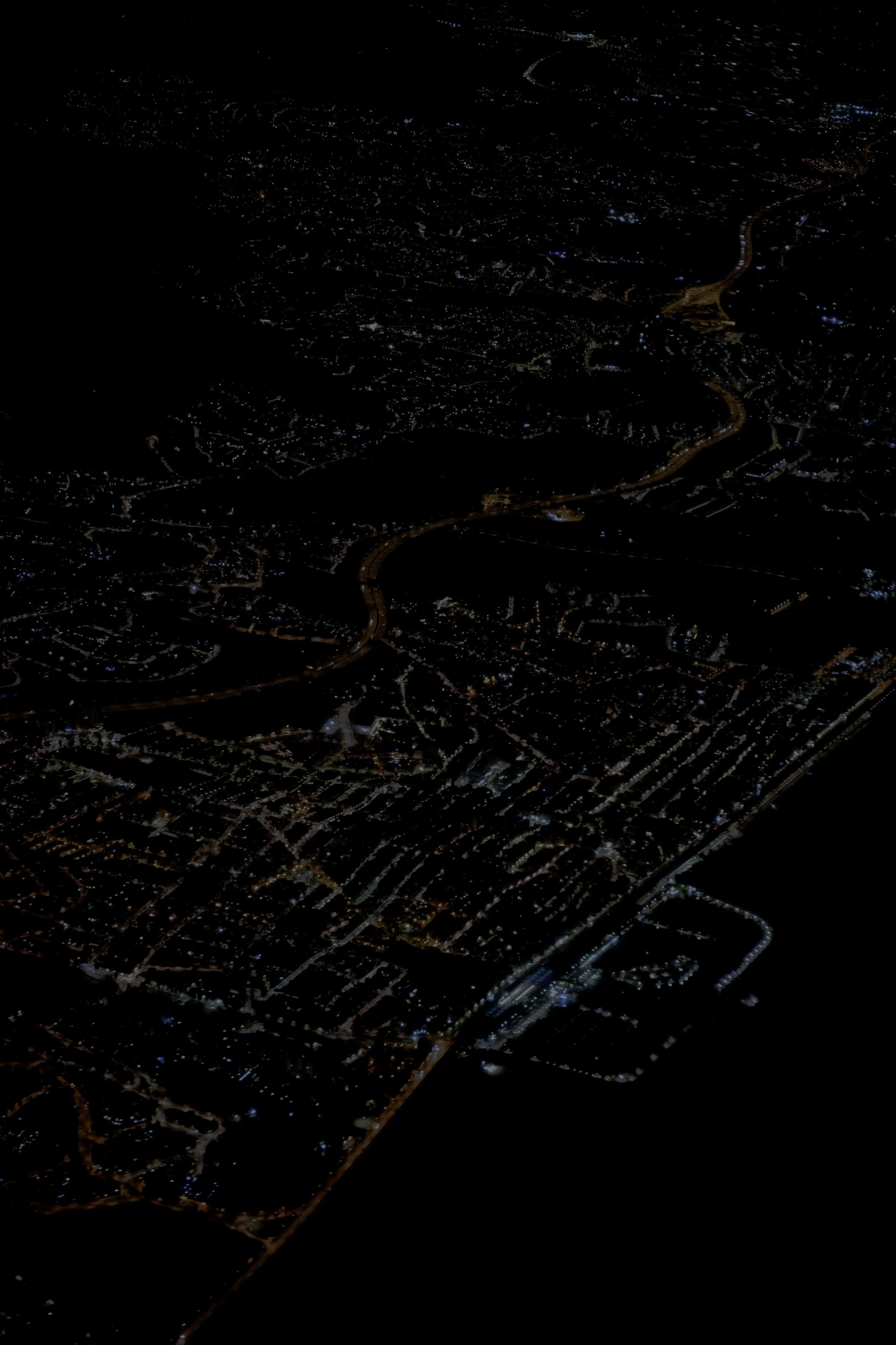 City lights spread across the ground at night, seen from the air