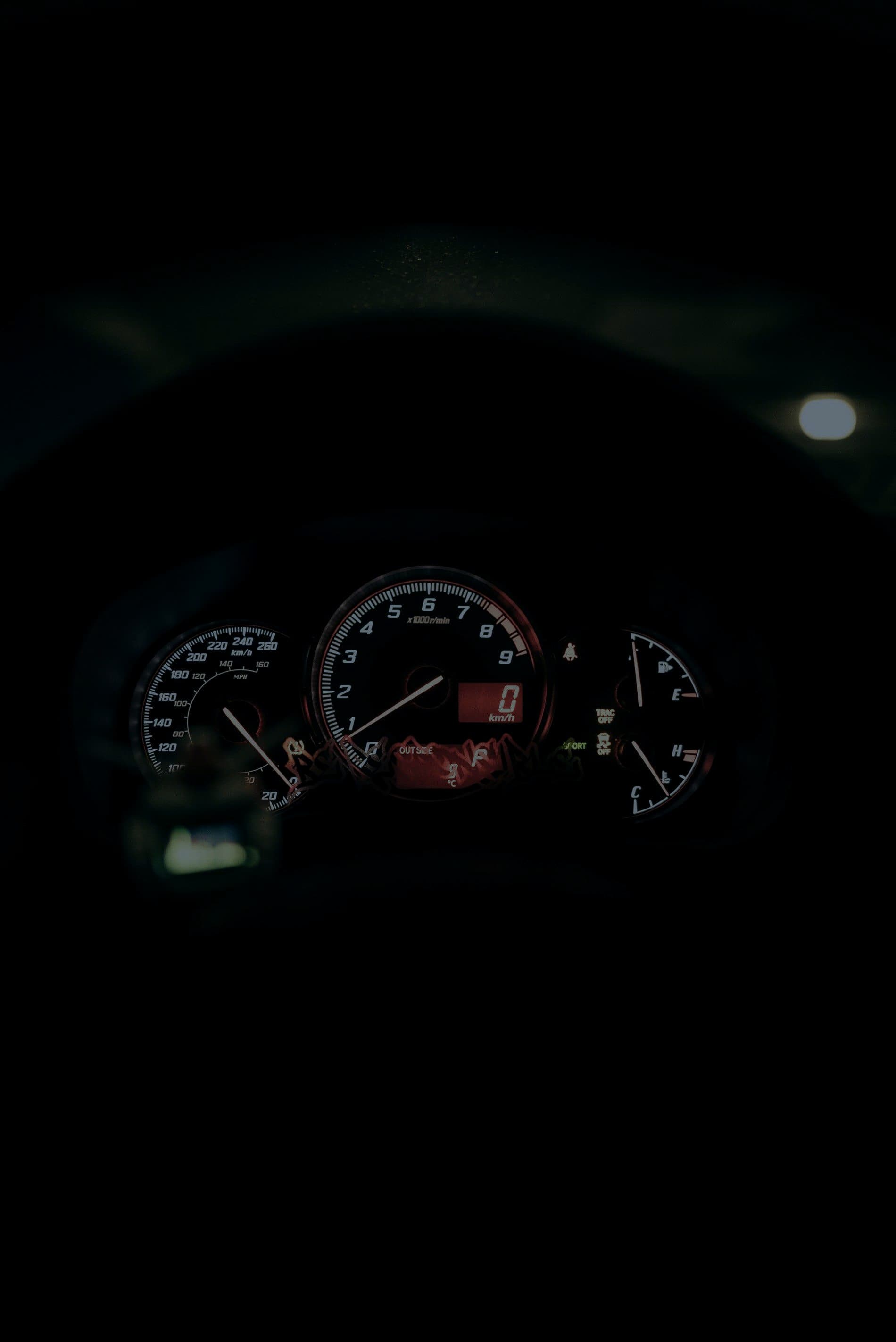 An illuminated vehicle instrument cluster at night