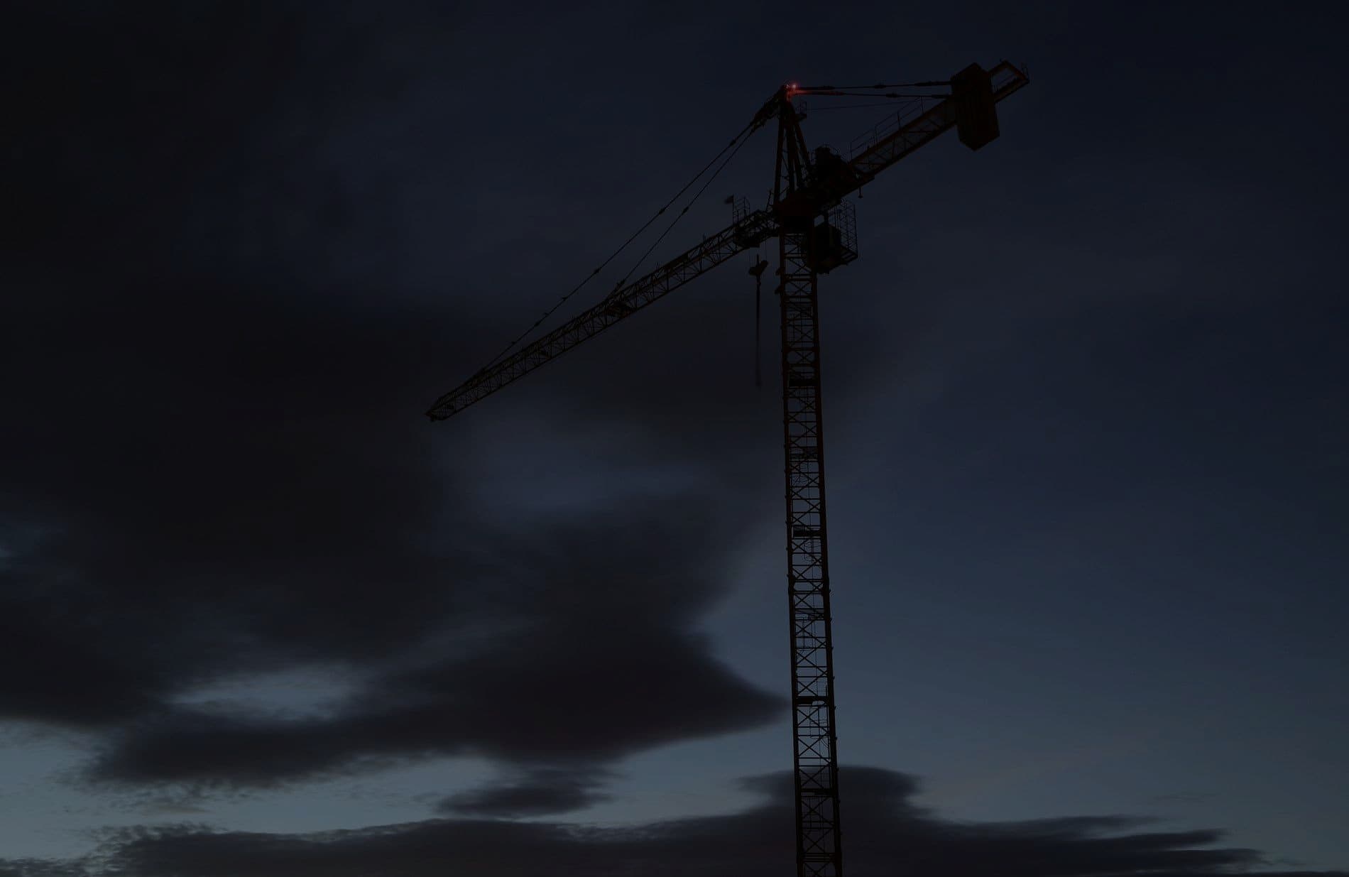 A tower crane against a darkening evening sky