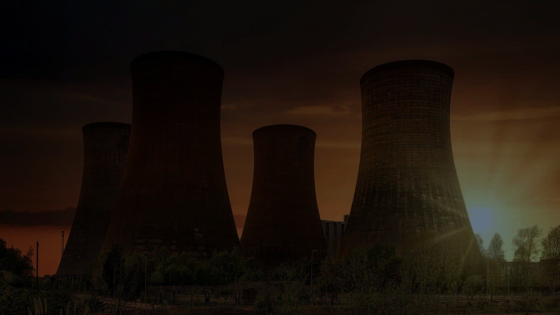 Power station cooling towers silhouetted at sunset