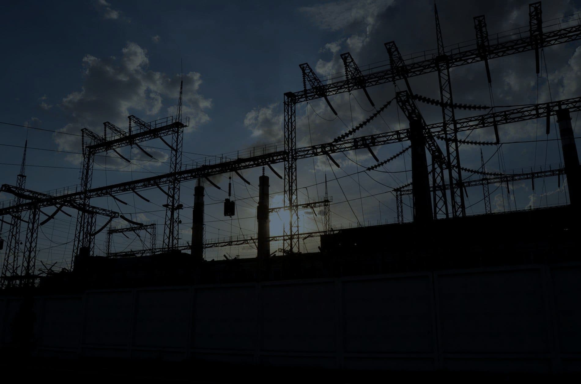 An electrical substation silhouetted against the sky