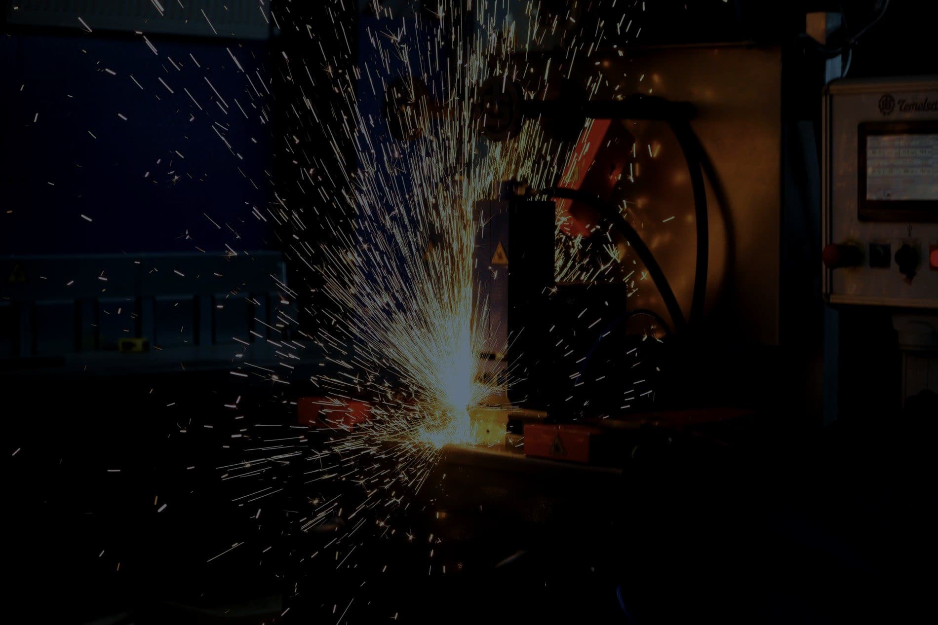 Sparks flying from industrial metalwork on a factory floor
