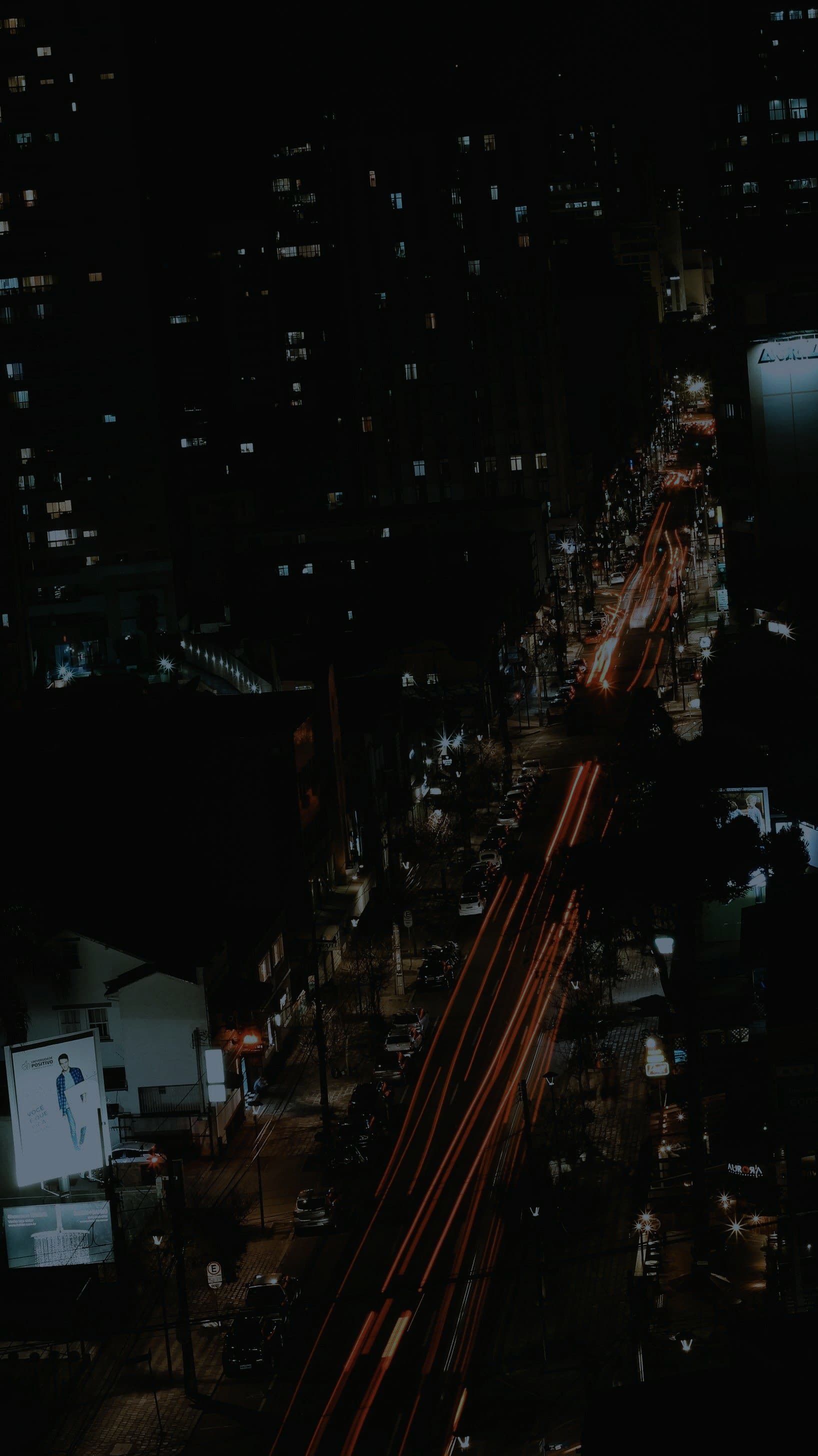 A city seen from above at night, its streets traced in light