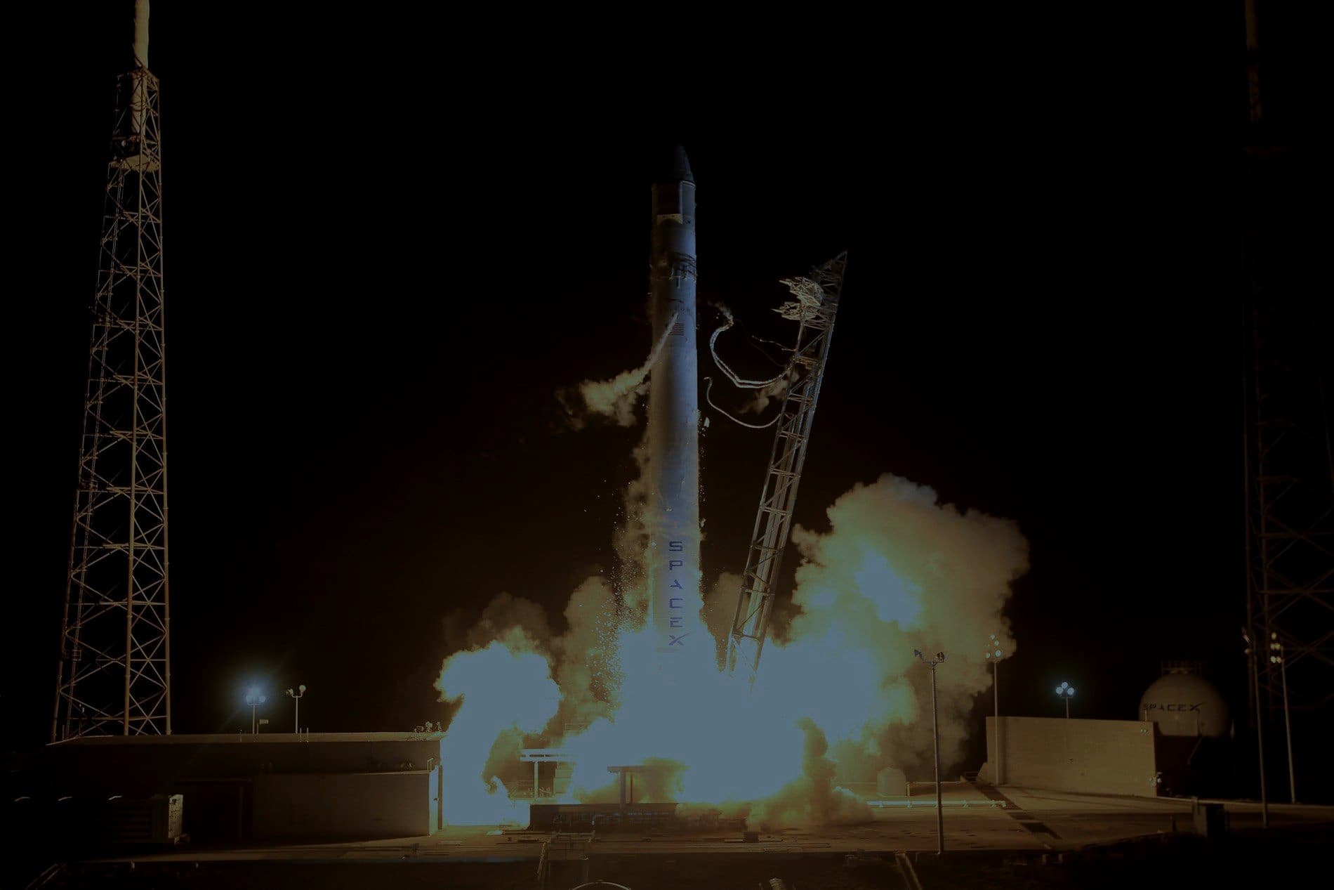 A rocket lifting off from its launch pad at night