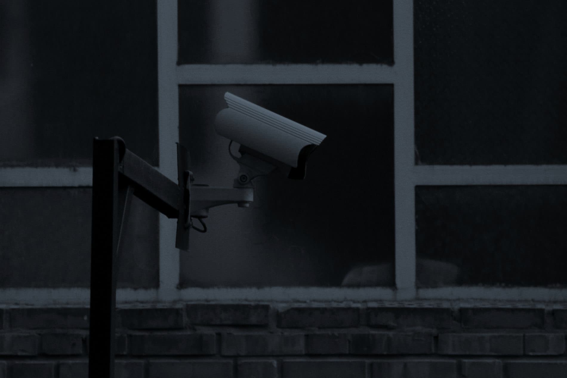 A wall-mounted security camera in black and white